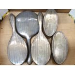 Five silver backed dressing table bushes and hand mirror