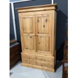 Modern pine double wardrobe with two panelled doors and four short drawers below, 128cm wide x 63cm