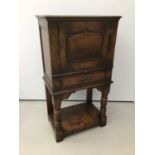 Antique style oak cupboard with panelled door, draw below on turned front supports with under tier 6