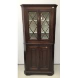 19th century mahogany two height corner cupboard, the upper glazed section enclosing shelves, above