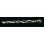 Good quality emerald and diamond bracelet of cross-over design with two articulated platted rows of