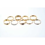 Eight gold rings to include five 22ct gold wedding rings, an 18ct gold diamond half eternity ring, V