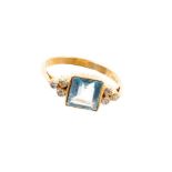 18ct gold square step cut aquamarine flanked by three diamonds to each shoulder