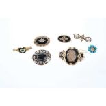 Seven Regency and Victorian mourning brooches to include a Regency gold enamel and emerald ring conv