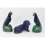 Pair of Chinese blue-glazed pottery parrots, late Qing period, modelled on naturalistic green bases,