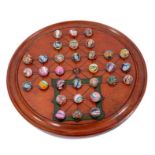 A Victorian solitaire board (also marked for the game of Fox and Geese) with antique glass marbles
