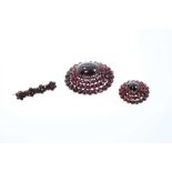 Large 19th century Bohemian garnet cluster oval brooch with central cabochon in tiered border, 49mm