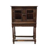 Antique oak food hutch enclosed by a pair of bared doors, on carved frieze and fluted turned support