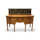 George III plum pudding mahogany bowfront sideboard, with rear brass gallery and central drawer flan