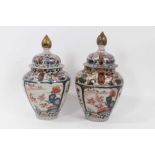 Near pair of Japanese Edo period Imari vases and covers, decorated with landscapes and flowers, 26.5