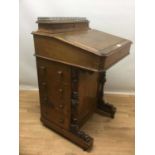 Victorian walnut Davenport, the leather lined slope front enclosing fitted interior and stationary c