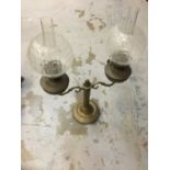 Antique brass oil lamp with twin shades.