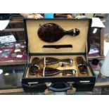 Faux tortoiseshell dressing table set with gilt Q initial, in a good quality fitted leather case ins