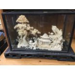 Chinese carved cork diorama depicting temples and trees in landscape, in a glazed case