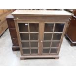 Blond oak dwarf bookcase, enclosed by two astragal glazed doors, 88cm wide x 103cm high x 27cm deep
