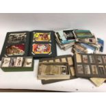 Box of postcards and cigarette cards, some in albums and some loose, some damp affected