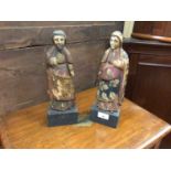 Pair of antique Continental painted wooden figures raised on ebonised bases