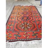 Eastern wool rug, second half 20th century, with geometric panels on orange ground