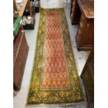 Eastern runner with geometric decoration on green and red ground, 290cm x 82cm