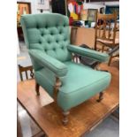 Victorian armchair upholstered in buttoned green material with turned beech legs on brass castors
