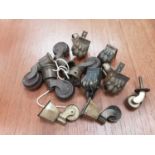 Collection of furniture fittings including brass castors, table clips, winding handles, and some clo