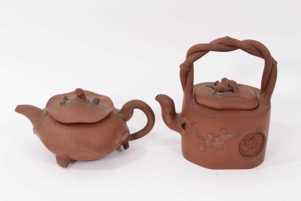 Two interesting Chinese terracotta teapots, one depicting lotus leaf with frog and snail