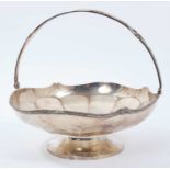 !920s silver cake basket of circular form, with faceted panels and reeded swing handle