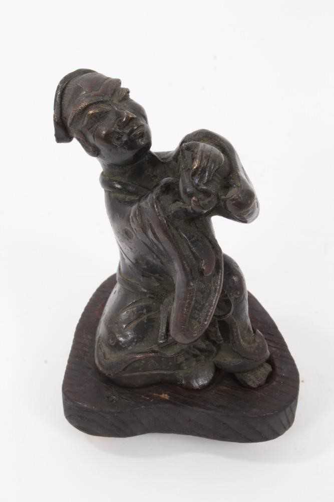 Chinese bronze figure of a man making a devotional offering, on a later wooden base