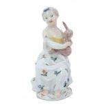 Meissen figure of a young girl, circa 1755, shown seated on a tree stump playing pipes, decorated in