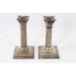 Pair of silver Corinthian column candlesticks on square bases