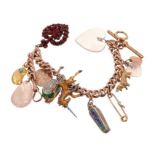 Gold charm bracelet with a rose gold curb link bracelet suspending a collection of antique and vinta
