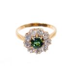 Green tourmaline and diamond cluster ring with a central round mixed cut green tourmaline surrounded