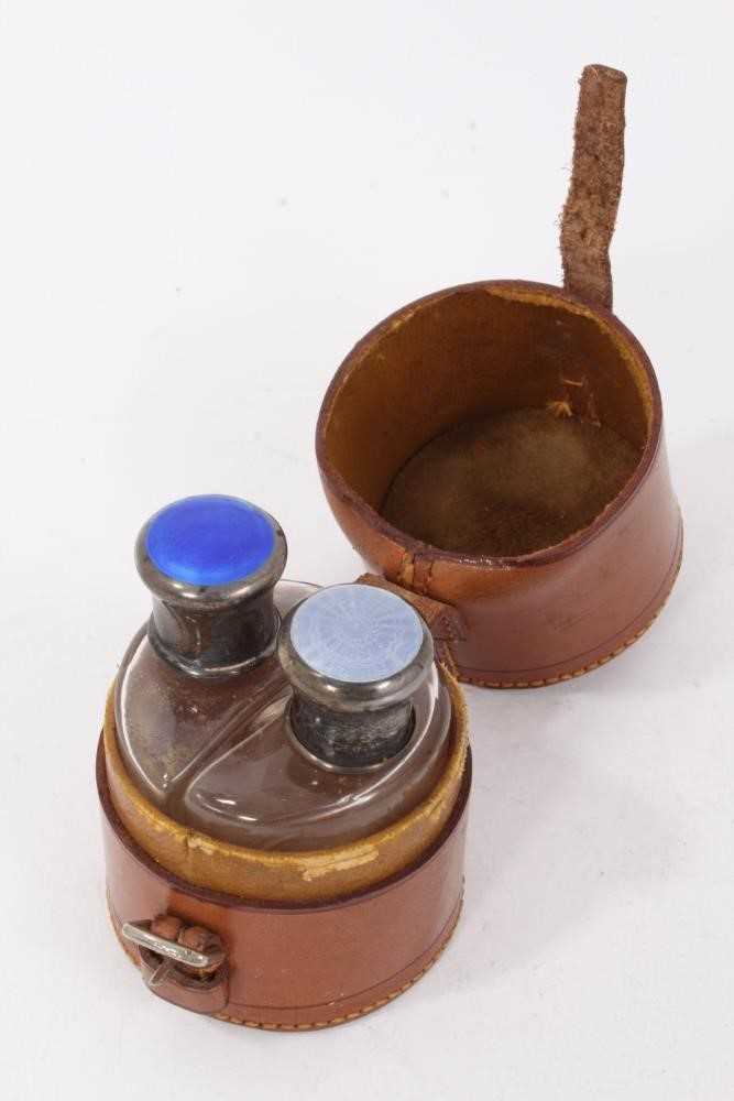 Two early 20th century glass scent bottles with silver and guilloche enamel tops in a leather case