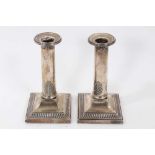 Pair 1920s silver candlesticks, with plain columns and leaf decoration, on square bases
