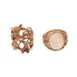 Two gold dress rings, one with a cabochon stone, the other with openwork woven floral design. Finger