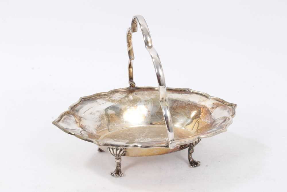 Edwardian silver swing handled dish of shaped oval form, with raised border and scallop handle,