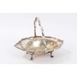 Edwardian silver swing handled dish of shaped oval form, with raised border and scallop handle,