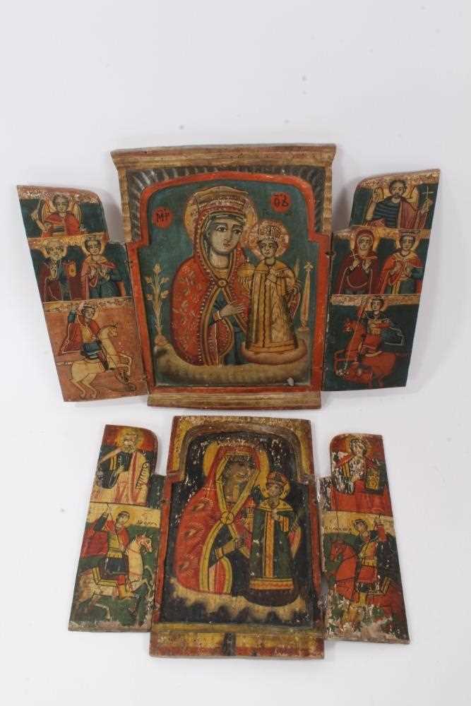 Two Greek Orthodox folk art folding triptych icons, the largest 31cm high
