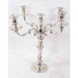Old Sheffield plate candelabrum on a scalloped base with scroll and floral borders