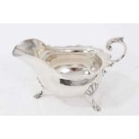 1940s silver sauce boat of conventional form, with wavy border and leaf mounted, open scroll handle