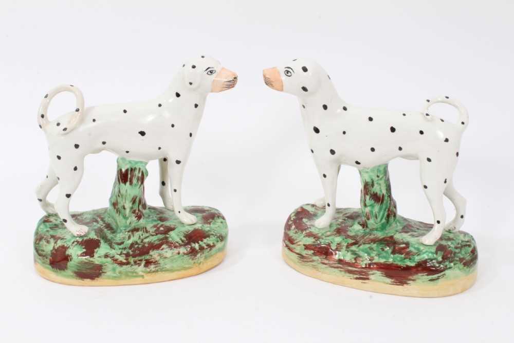 Pair of Staffordshire pottery models of Dalmatians, shown standing on naturalistic bases, 16cm high