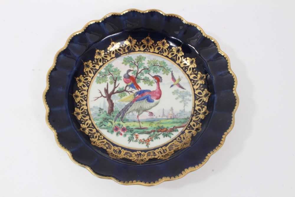 Worcester plate, circa 1770, of fluted form, polychrome painted with exotic birds, on a cobalt blue
