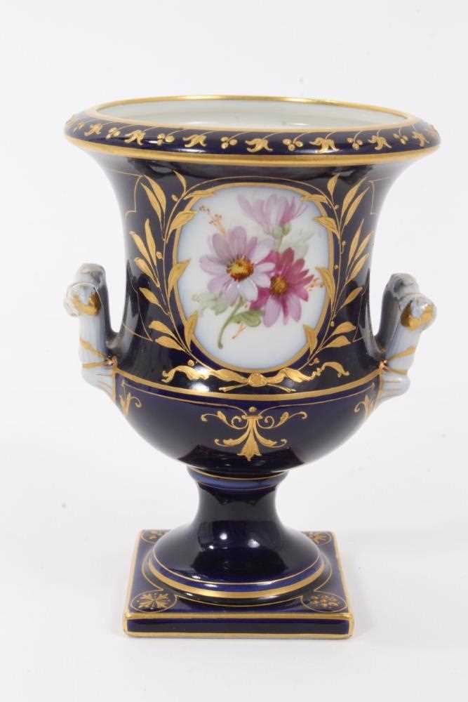 Small Berlin porcelain campana vase, circa 1880, painted with flowers on a gilt and cobalt blue grou