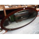 Large oval bevelled wall mirror in mahogany frame, 128cm x 62cm