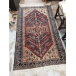 Eastern rug with geometric decoration on red, blue and orange ground, 190cm x 106cm