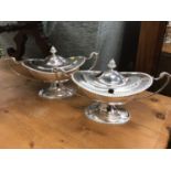 A pair of silver plate sauce tureens in the Adam style of oval form on a raised foor with gadroon bo