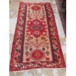 Eastern rug with geometric decoration on red, blue and beige ground, 210cm x 107cm