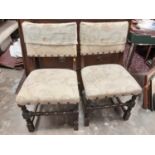 Set of four oak dining chairs with studded cream upholstered seats and backs on turned and block leg