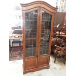 Early 20th century walnut dome top bookcase with shelved interior enclosed by two leaded glazed door