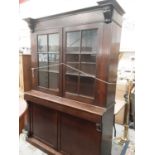Late 19th century oak two height bookcase with shelved interior enclosed by two glazed doors, frieze